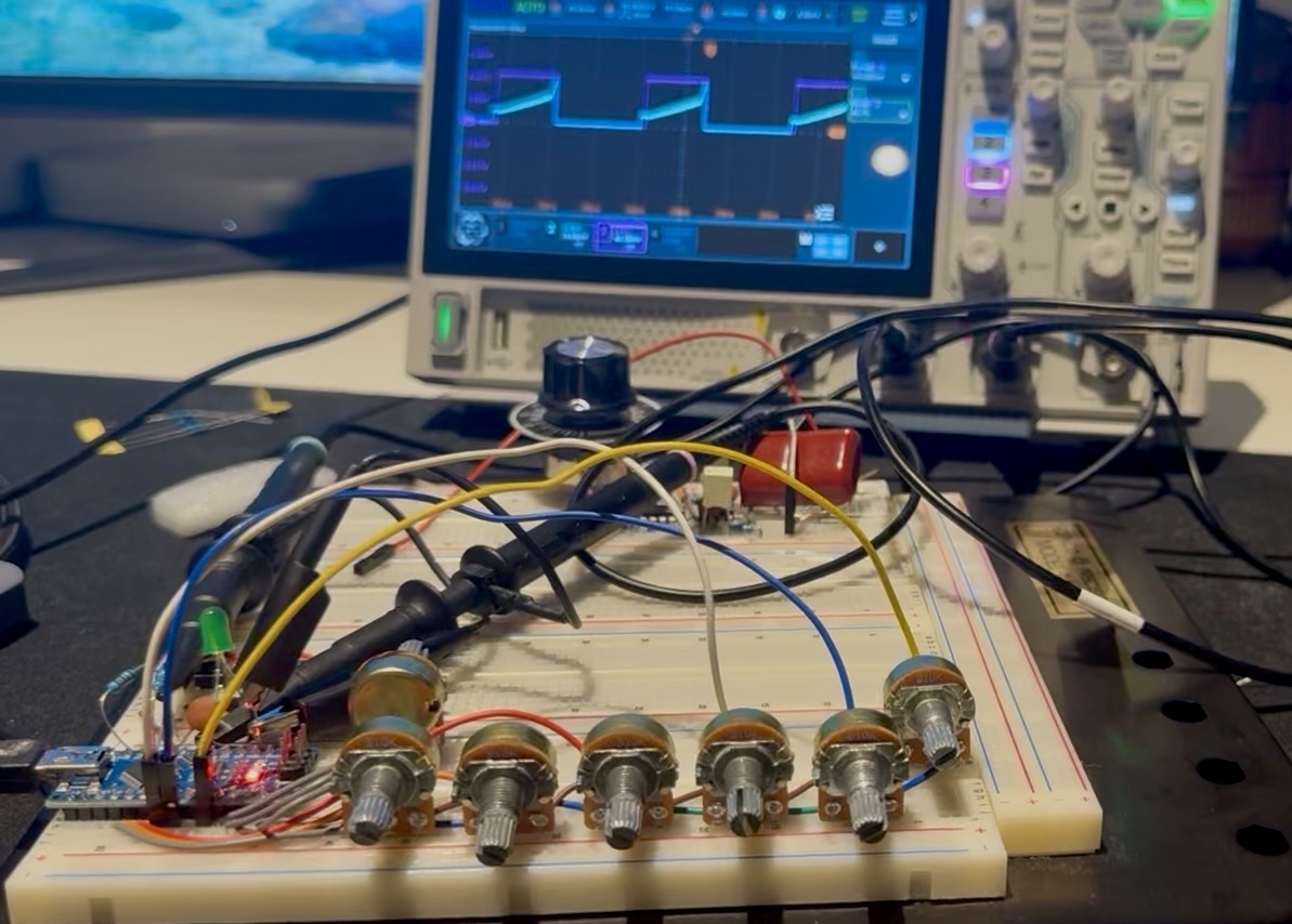 An Arduino wired across a breadboard to six potentiometers, probes clipped on, an oscilloscope behind it showing the waveform
